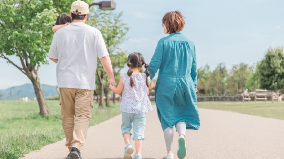 家族で手をつないでお出かけする後ろ姿