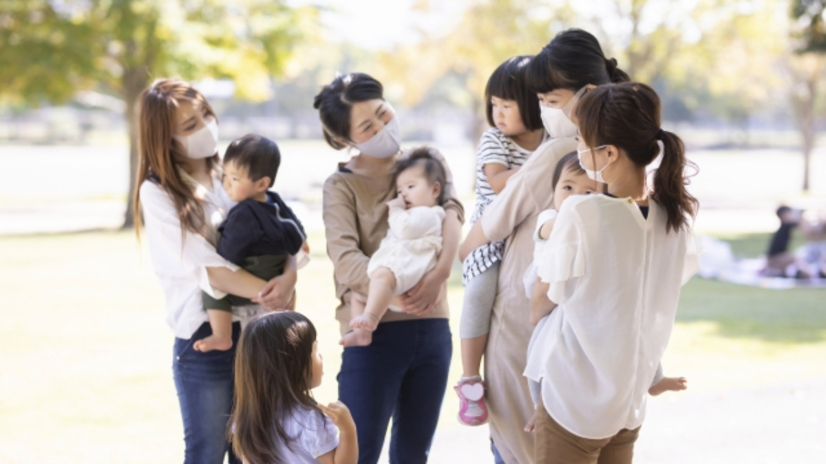 公園で談笑するマスクのママたち