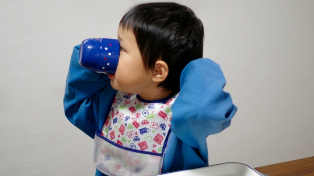 コップでがぶ飲みする子ども