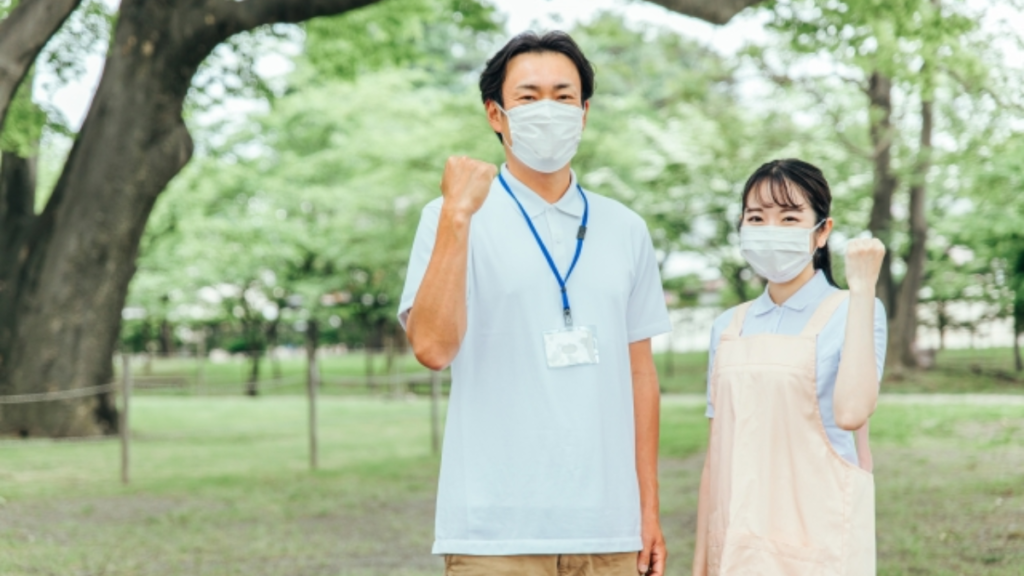 ガッツポーズをする男女の福祉職員