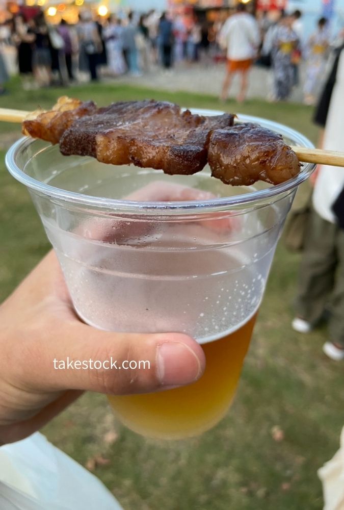 ビールと串焼きを持つ手